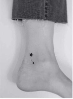 a black and white photo of a person's foot with a star tattoo on it