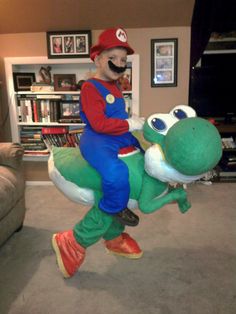 a man riding on the back of a green and white frog mascot in a living room