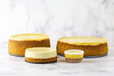 three cakes sitting on top of a white counter