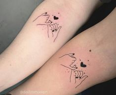 two people with tattoos on their arms holding each other's hands and heart shapes