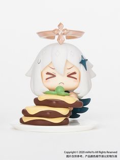 an anime figurine sitting on top of a stack of hamburgers