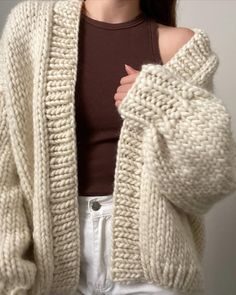 a woman wearing a white knitted cardigan