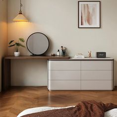 a bedroom with a bed, dresser and mirror on the wall next to each other