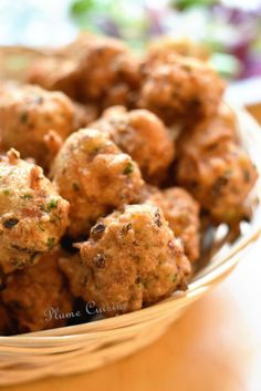 a bowl filled with meatballs sitting on top of a wooden table