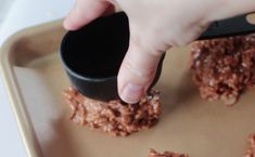 a person is dipping something into some food on a cookie sheet with a spatula