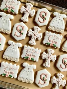 decorated cookies in the shape of baby's first christmas gifts on a cookie sheet