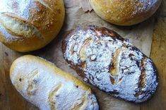 several loaves of bread sitting on top of a cutting board