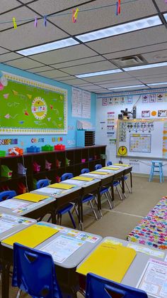 an empty classroom with desks and chairs in front of a bulletin board on the wall