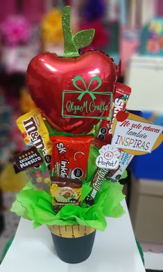 a cupcake with candy, candies and an apple in it sitting on a table