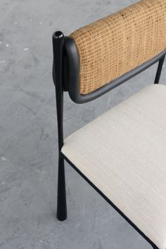 a close up of a chair with a woven seat cover on the back of it