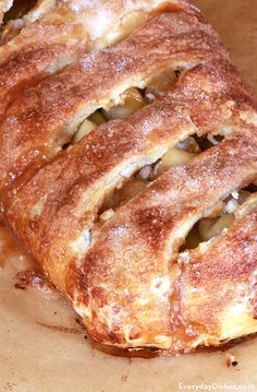 an apple pie is cut into pieces on a cutting board