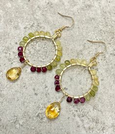 These earrings feature sparkly microfaceted gemstone beads and a citrine briolette wire wrapped in 14k gold filled wire.  The gemstones in these earrings include: - citrine - tsavorite garnet - plum tourmaline The beads and briolette are wrapped in 14k gold filled wire in a hoop-like design with the citrine dangling below the hoop.  All components of these earrings are handmade, and all of the gemstones are genuine, earth-mined gems.   These earrings: - are hypoallergenic; suitable for those wit Wire Wrapped Citrine Dangle Earrings, Yellow Wire Wrapped Drop Earrings, Faceted Citrine Dangle Jewelry, Handmade Round Citrine Earrings, Hoop Jewelry With Faceted Beads For Gifts, Small Hoop Jewelry With Faceted Beads For Gifts, Wire Wrapped Citrine Dangle Jewelry, Yellow Faceted Dangle Earrings, Yellow Wire Wrapped Dangle Jewelry