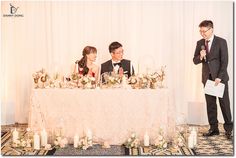 a man and woman standing next to each other at a table with candles on it