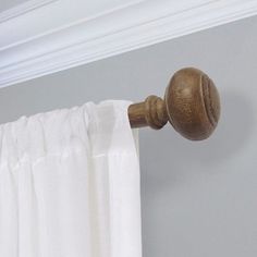 a curtain with a wooden handle hanging from it's side