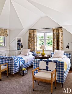 two beds in a room with blue and white furniture