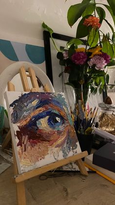 an easel with flowers and paintings on it