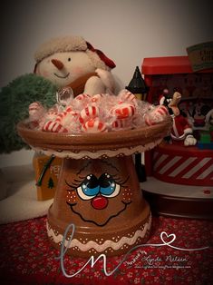 there is a christmas decoration with candy in the bowl and a teddy bear on the other side