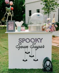 a spooky sun sugar stand in the grass with balloons and decorations on it