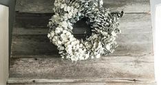 a wreath is hanging on the side of a wooden wall in front of a door