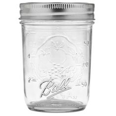 a glass mason jar with a metal lid and screw cap on the top is shown in front of a white background