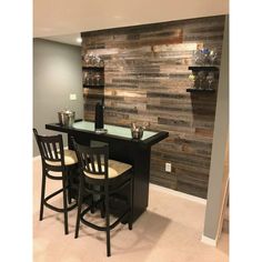 a bar with three stools next to it in a room that has wood paneling on the wall