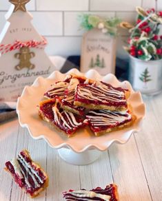 a white plate topped with pieces of cake next to a christmas tree