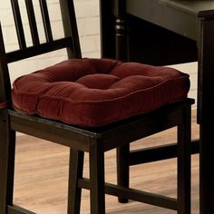 a chair with a cushion on it sitting in front of a table and two chairs