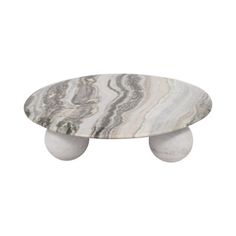 marble coffee table with two white balls on each side and an oval design in the middle