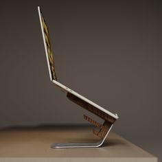 an open laptop computer sitting on top of a wooden table next to a metal object