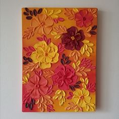 an orange and red flowered painting on a wall