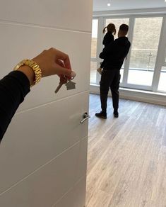 two people standing in an empty room, one is holding a key to the door