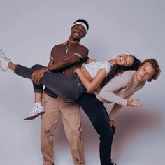 two men and a woman are posing for the camera while holding each other in their arms