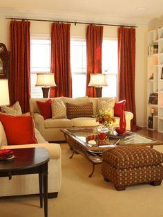 a living room filled with furniture and red curtains