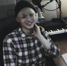 a young boy smiles while sitting in front of a keyboard