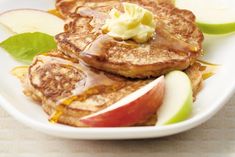 pancakes with butter and apples on a white plate