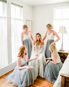 a group of women sitting on top of a wooden floor in front of a window