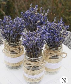 three mason jars filled with lavender flowers on top of a table