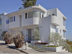 a large white house with many windows and plants