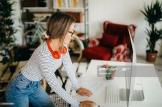 a woman sitting at a desk using a laptop computer