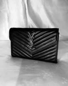 This stylish and elegant YSL black bag brings together classic and modern touches. It is completed with soft black leather texture, elegant stitching details and silver YSL logo. It is suitable for both shoulder and hand carrying thanks to its chain strap. Its small size completes your elegance in daily use. The interior is designed to fit your daily items comfortably. A perfect choice for women who want to make a difference with a vintage atmosphere. Ysl Black Bag, Black Leather Texture, Ysl Logo, Stitching Details, For Her Gifts, Leather Texture, Black Chain, Black Bag, Soft Black