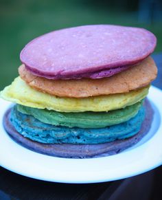 a stack of colorful cookies sitting on top of a white plate