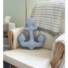 a blue anchor pillow sitting on top of a white chair