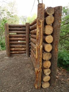 logs stacked on top of each other in front of a gate