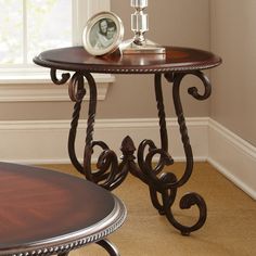 a wooden table with a clock on it next to a window