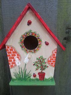 a birdhouse with flowers and plants painted on it