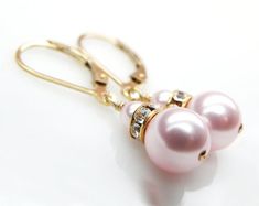 Simple and elegant Swarovski pearl earrings in a sweet soft pink hue. Accented with gold Swarovski crystal rhinestone crowns. Handmade with 14k gold filled wire and leverback earring closures (ones which clasp on the back). Short drop earrings are the perfect accessory for weddings, dress up events, and everyday. Makes for a sweet gift for your bridal party on your wedding day. A great feminine gift for women who love pink and gold jewelry.Earrings Details:- Earrings are 1.25 inches (3.17 cm) lo Classic Pink Earrings For Wedding, Pink Drop Pearl Earrings For Formal Occasions, Pink Feminine Pearl Earrings For Wedding, Feminine Pink Pearl Earrings For Wedding, Pink Pearl Bridal Earrings As Gift, Pink Pearl Bridal Earrings For Gift, Elegant Pink Pearl Earrings For Anniversary, Pink Pearl Bridal Earrings For Wedding, Elegant Round Pink Bridal Earrings