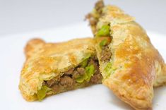 two pastries on a white plate with one cut in half