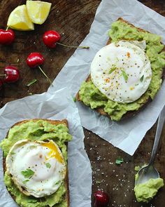 avocado toast with poached egg and sour cream on top, topped with cherries