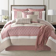 a bed with pink and white comforters in a bedroom