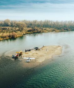 an aerial view of several small planes on the shore